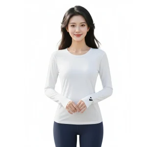 一位穿著白色長袖圓領保暖內搭衣的女性，袖口印有 KOMIA 黑色LOGO，搭配深藍色瑜珈褲。