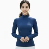 TORAY長袖小立領保暖防曬內搭衣-深藍 3 一位穿著藍色長袖小立領保暖內搭衣的女性,搭配白色瑜珈褲。
